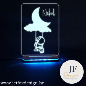 Personalizirana LED lampa s motivom "Astronaut snova na ljuljački" i imenom po želji. Savršen poklon za djecu i ljubitelje svemira, koji unosi magiju i toplinu u svaki prostor.